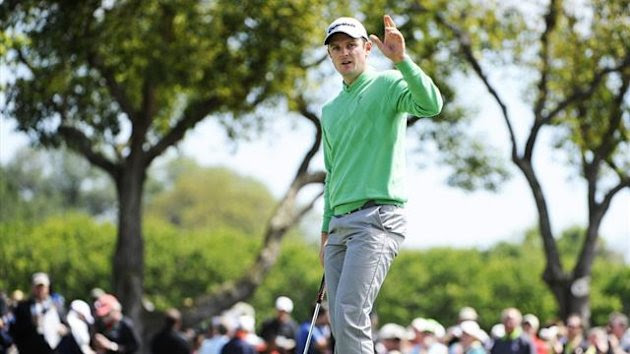 Britain's Justin Rose waves to the crowd after sinking his putt on the ninth green to finish his round atop the leaderboard during first round play in the Arnold Palmer Invitational (Reuters)