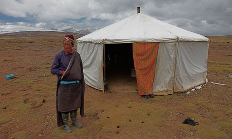 Tibetan nomad  Phuntsok Dorje outside his tent on grasslands turning to desert, Tibet