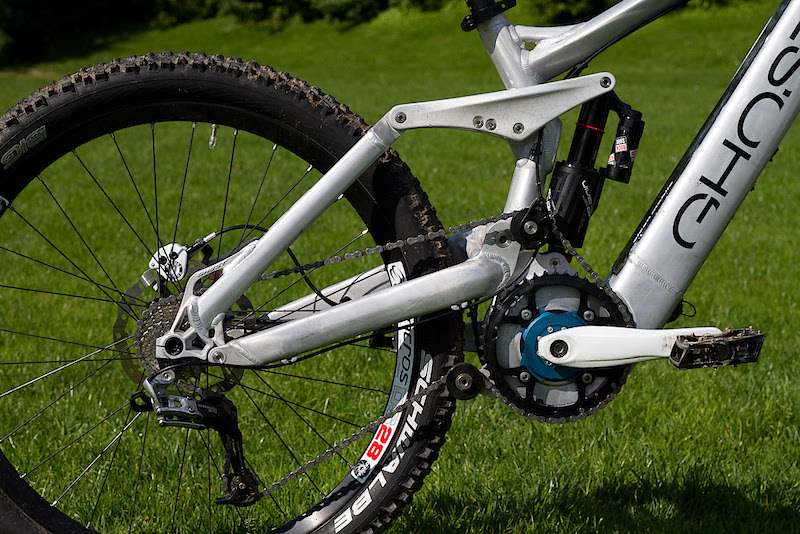 This is not an electric bike that you can ride on trails, but rather a full on mountain bike that has an electric motor - if you've seen past attempts at most electric mountain bikes you'll know what I'm getting at. The rear suspension design and components are actually the very same as Ghost uses on their new DH race bike, albeit with a slightly shorter stroke damper. They employ a high main pivot that results in a axle path that has a more rearward element than if they had placed the pivot in a more conventional location. Because it is so high they bolt on a chain idler to keep chain tension and growth in check. Have you spotted the battery yet?