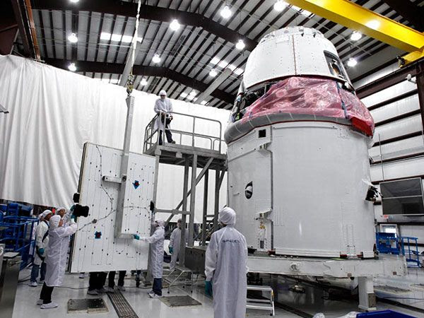 One of two solar panels is about to be attached to the Dragon spacecraft's service module at Cape Canaveral Air Force Station in Florida.