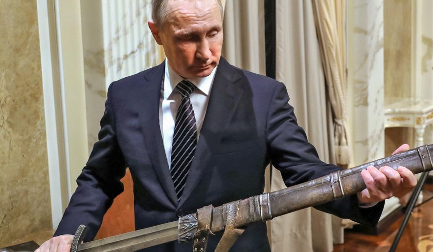 Russian President Vladimir Putin holds a sword while listening an explanations from the head of Russian First Channel Konstantin Ernst, during his meeting with the historical action film Viking's crew, in Moscow, Russia, Friday, Dec. 30, 2016.  Viking is a historical action film based on the historical document Primary Chronicle and Icelandic Kings' sagas. (Mikhail Klimentyev, Sputnik, Kremlin Pool Photo via AP)