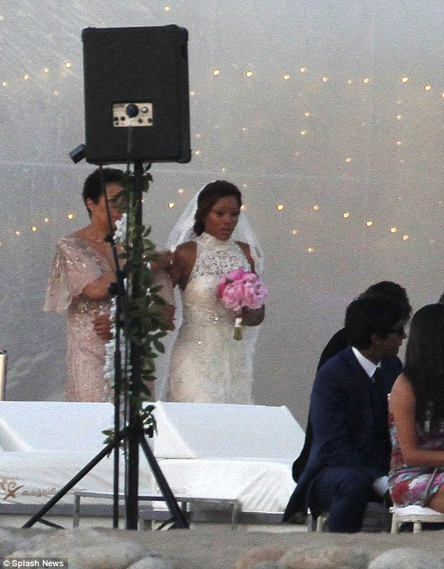Here comes the bride! The star donned a stunning intricately embroidered Alice Temperley gown featuring a high neckline and slit up the centre of the skirt as she was walked down the aisle by her mother, Julia Wilch-Jeffers, while she carried a bouquet of soft pink peonies and donned a traditional veil