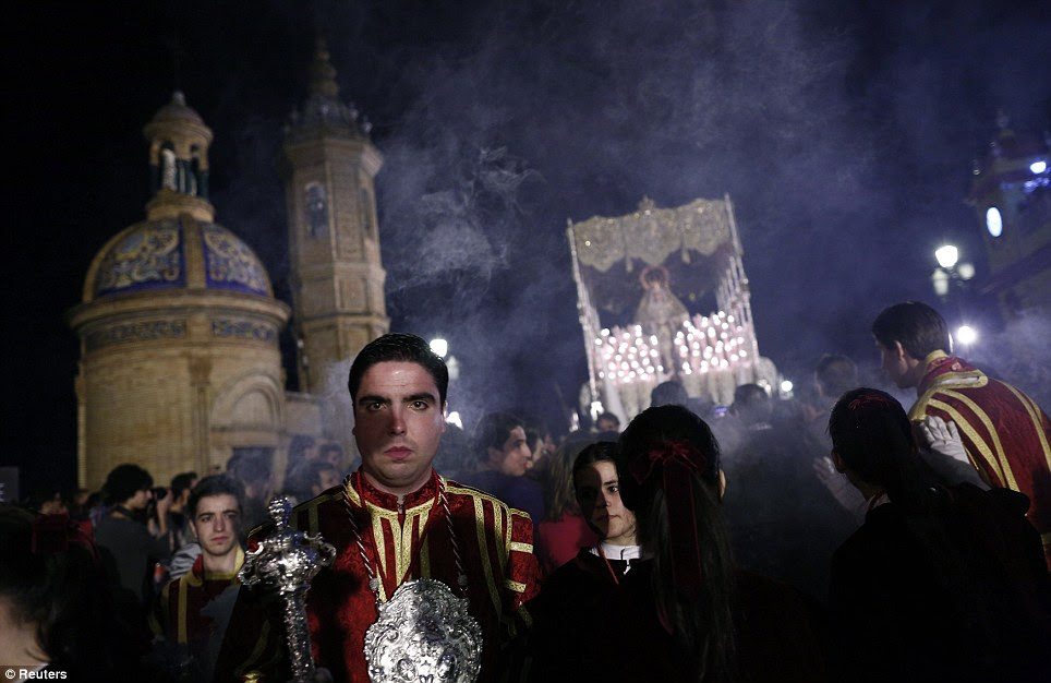 Marching on: Penitents carry a huge float of the Virgin Mary as part of their procession through the streets of Seville