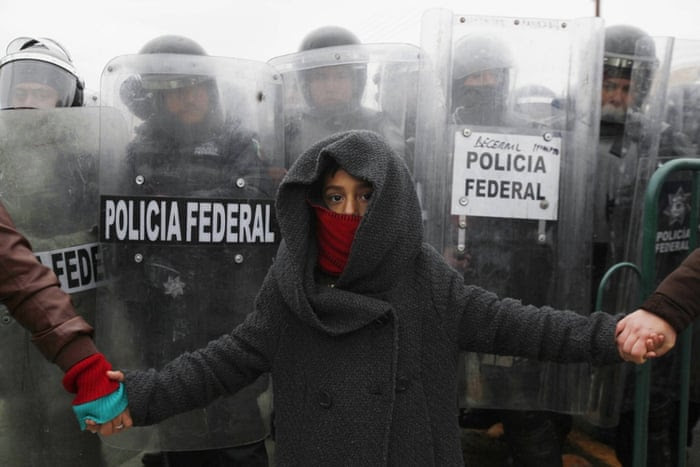 A child holds hands with demonstrators while standing in front of federal police during a protest against the visit of Mexico’s president, Enrique Peña Nieto, to Ciudad Juarez