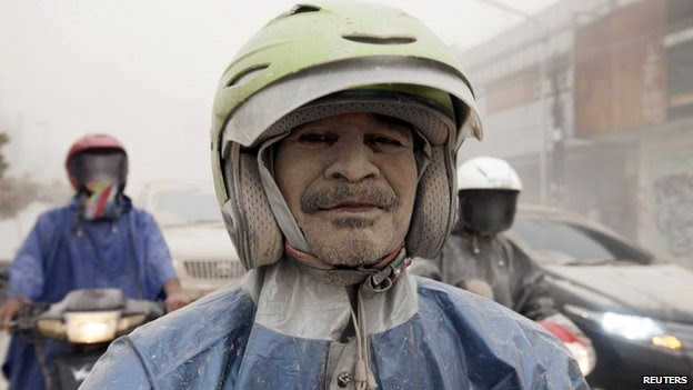 A man covered with ash from Mount Kelud is seen on his motorcycle in Yogyakarta, 14 February 2014