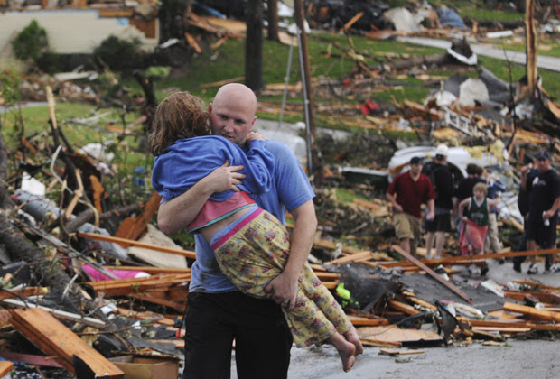 Homem socorre jovem garota que teve a casa atingida pelo tornado na cidade de Joplin (Foto: AP) Homem socorre jovem garota que teve a casa atingida pelo tornado na cidade de Joplin (Foto: AP)