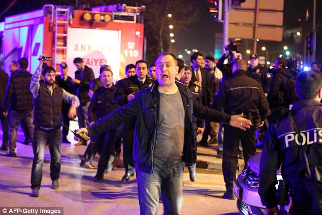 Chaos: A man reacts next to policemen near the site of an explosion after an attack targeted a convoy of military service vehicles in Ankara