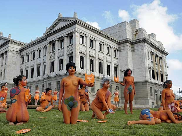 Mulheres nuas e com os corpos pintados realizam manifestação na frente do Parlamento uruguaio. (Foto: Matilde Campodonico / AP Photo)