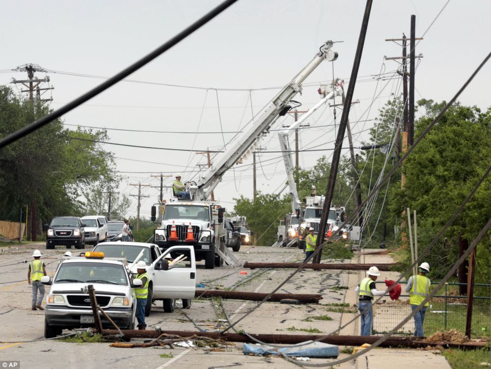 Downed: Utility workers try to restore electric power on downed lines on Thursday in Cleburne