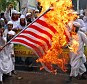 Fury: Muslim men in Bangladesh burned an American flag during protests against an anti-Mohammed film on Thursday