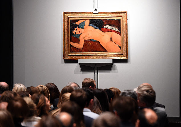 Crowds sit in front of Amedeo Modigliani's "Nu couche" during the "Artist Muse: A Curated Evening Sale" November 9, 2015 at Christie's New York November 9, 2015. The painting sold for USD170,405,000. AFP PHOTO / TIMOTHY A. CLARY ORG XMIT: TC006