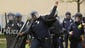 A Baltimore Police officer throws a rock back at violent
