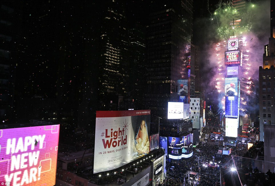 The glittering crystal ball dropped with a burst of confetti and dazzling fireworks as revelers rang in 2018 in frigid Times Square
