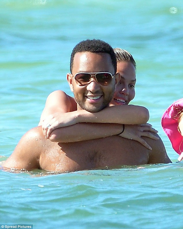 Fun in the sun: The 36-year-old singer couldn't hide his smile as his gorgeous wife showered him with affection