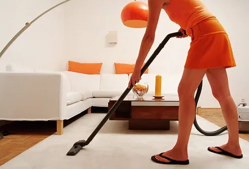 Woman vacuuming living room rug