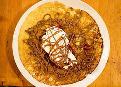 Crêpes, whipped cream, strawberry jam and melted chocolate