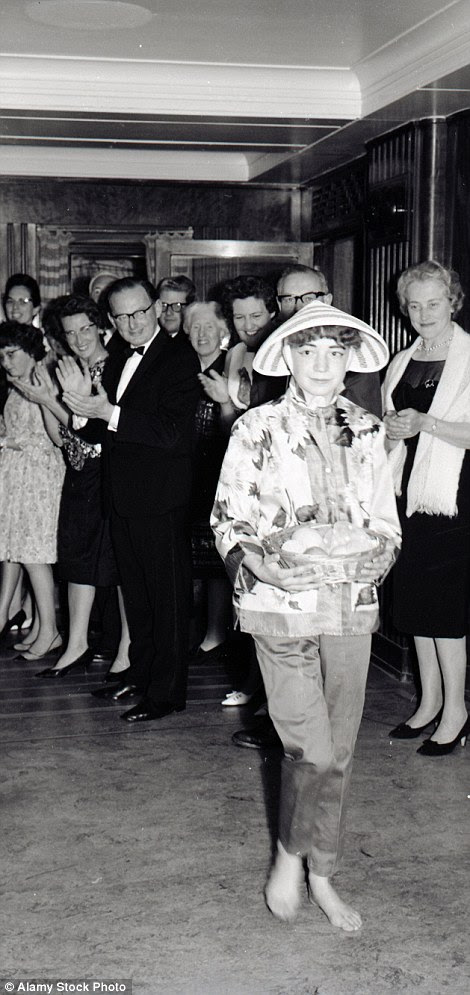Passengers clapping as they play a 'guess the national costume' competition, using models dressed with clues and traditional dress