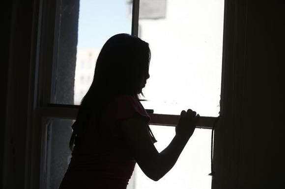 Maria, 18, who is an undocumented migrant from Central America, looks out of a window in Los Angeles, California, July 22, 2014. REUTERS/Lucy Nicholson