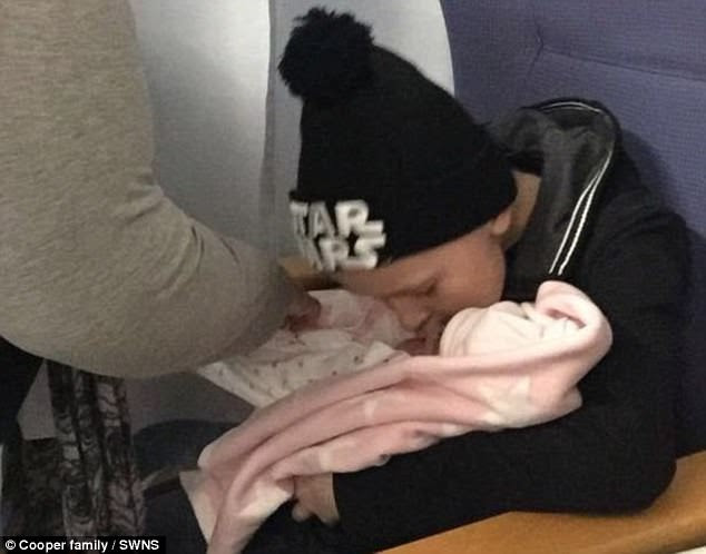 First cuddle: Bailey holding baby sister Millie for the first time after she was born in November