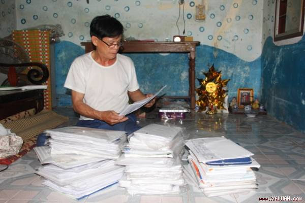 Ông Lộc cùng đống đơn thư tính bằng kg đi đòi bồi thường do bị kết án oan. Ảnh: Ngọc Vũ