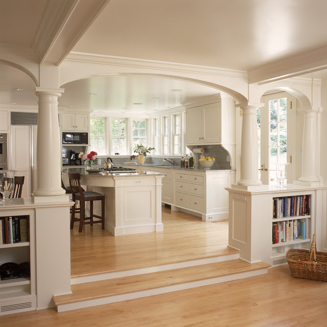 White kitchen and breakfast room with fireplace and arches 