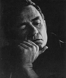 A black-and-white photo of Cash holding his face