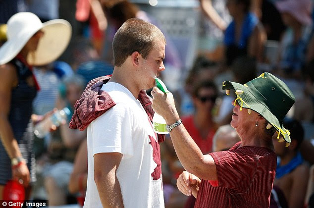 Protections: Tennis fans apply sun cream to protect themselves from burning under the hot Melbourne sun