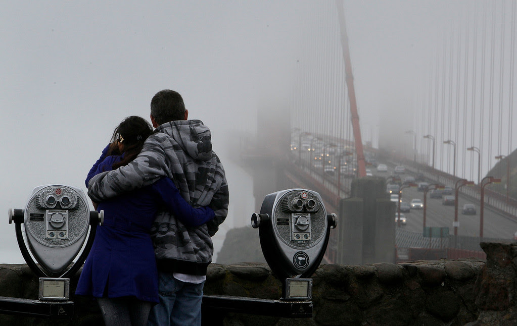Description of . A couple looks toward the Golden Gate Bridge from a vista point in Marin County, Calif., Monday, June 6, 2011. (AP Photo/Jeff Chiu)