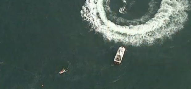 Equipes de resgate buscam os tripulantes do helicóptero do Corpo de Bombeiros que caíram no mar na praia de Copacabana, no Rio de Janeiro (Foto: Reprodução TV Globo)