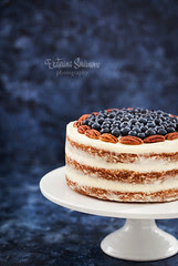 Naked carrot cake decorated with fresh blueberry and pecan