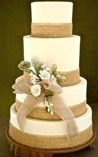 wedding cake with burlap wrapping..without the white flowers but purple and orange flowers instead..