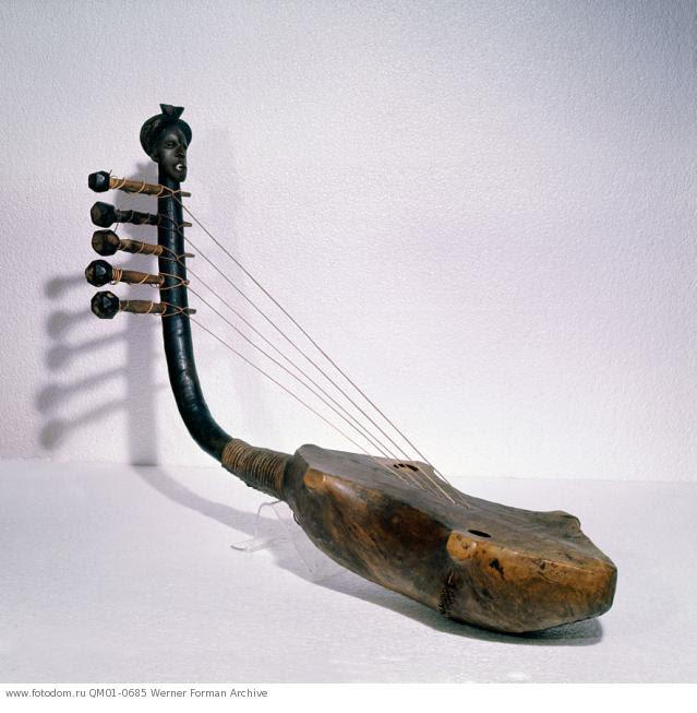Harp with handle decoration, depicting a Mangbetu head. The hairstyles of prestigious Mangbetu groups were much imitated among neighbouring peoples, in particular the Zande. Country of Origin: Democratic Republic of Congo, Equatorial Africa. Culture: Mangbetu / Zande. Date / Period: 19th-20th C. Place of Origin: Northeastern Congo. Material Size: Wood, leather. Credit Line: Werner Forman Archive / Musee Royal de l'Afrique Centrale, Tervuren. Location: 11.