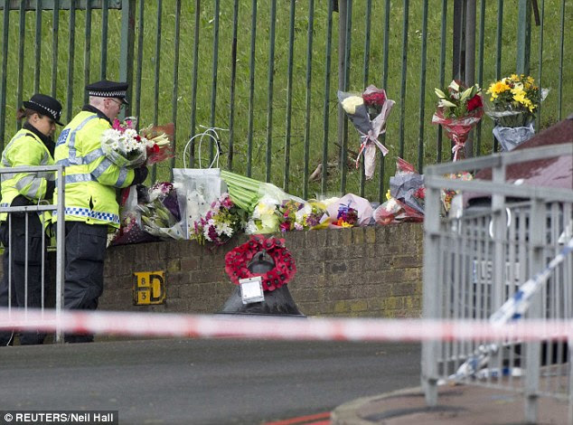 Grief: Flowers pile up for the dead soldier who was murdered in Woolwich, south-east London, yesterday