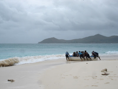 Pulling a dinghy into the water at Cousin Island near Praslin (Seychelles)
