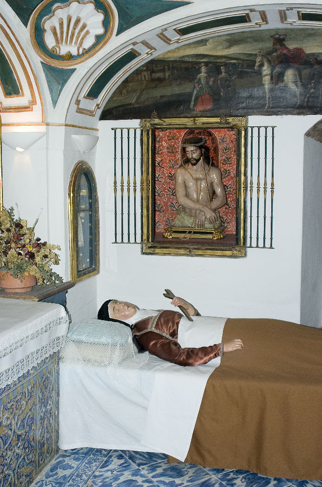 This is the room where St. Teresa died. Shortly before St. Teresa died, Bl. Ana de San Bartolomé saw Our Lord at the foot of St. Teresa’s bed in majesty and splendor, attended by myriad angels, and at the head, the Ten Thousand Martyrs who had promised St. Teresa, in a rapture years before, to come for her in the moment of death. When she sighed her last, one of the sisters saw something like a white dove pass from her mouth. And while Sister Catalina de la Concepción, who was very holy and had less than a year to live, was sitting by the low window opening on the cloister by La Madre’s cell, she heard a great noise as of a throng of joyful and hilarious people making merry, and then saw innumerable resplendent persons, all dressed in white, pass the cloister and into the room of the dying Saint, where the nuns gathered about her seemed but a handful in comparison; and then all advanced toward the bed. And this was the moment when St. Teresa died.