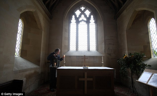 Time to remember: Imber volunteer archivist James Kirkwood lights a candle ahead of the 10th New Year's Eve peace vigil which was held inside the 700-year-old St Giles Church