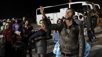 Refugiats esperant pujar als autobusos que es dirigeixen als centres de registre (Reuters)