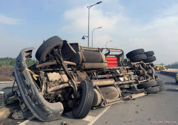 Xe đầu kéo và thùng container lật ngang tại chân cầu Phú Hữu. Ảnh: Tin Tin.