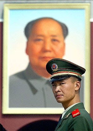Un policía chino en la Plaza de Tiananmen, bajo un retrato de Mao. | F. Brown