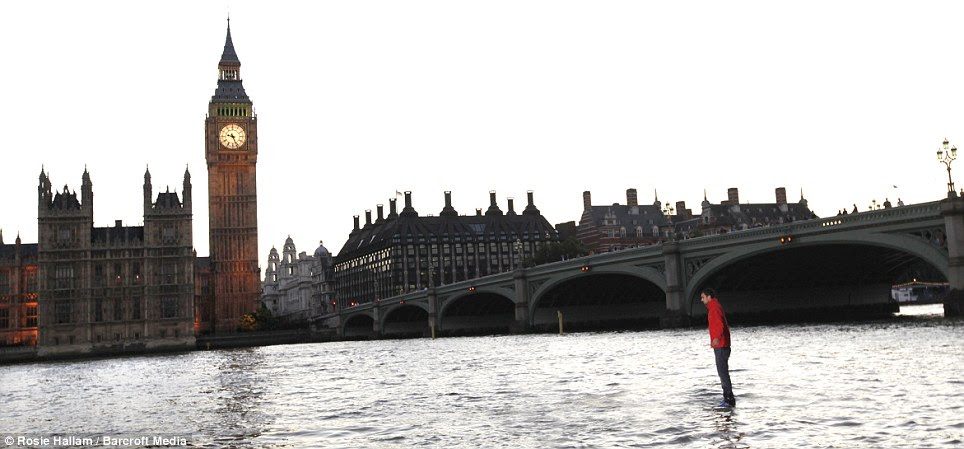 I hope he can swim: Frayne stands still in the middle of the  fast-moving River Thames