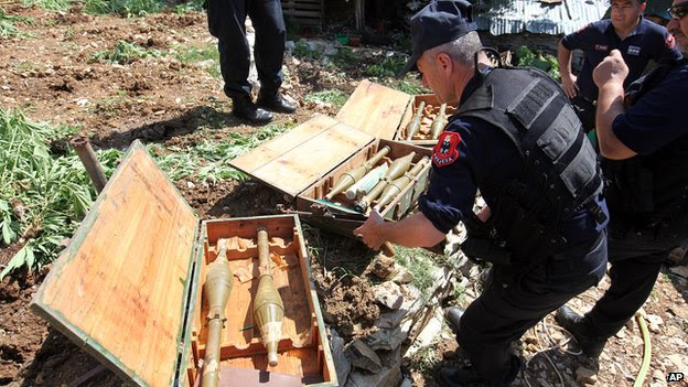 Albanian police officers display seized heavy guns in the lawless village of Lazarat on 20 June 2014