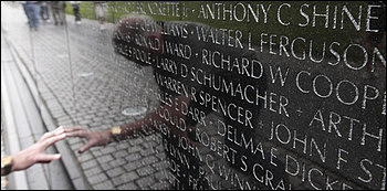 A visitor touches a name on the Vietnam Veterans Memorial.