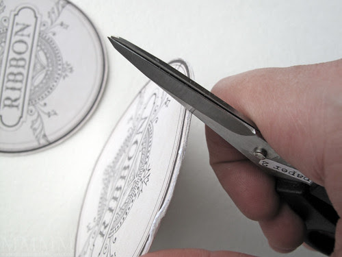 Step 8) Score the edges of your new double sided label with scissors to even the edges out & distress it