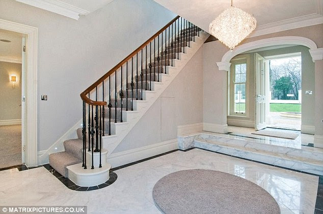 Luxury living: The house features lighting along the staircase, chandeliers and marble flooring