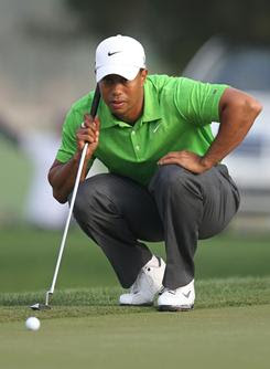 Tiger Woods lines up a putt on his way to a 6-under 66 during the second round of the Dubai Desert Classic on Friday.