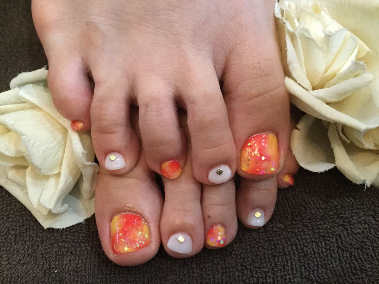 夏フットネイルオレンジイエローのタイダイ柄 Nail Salon Freestyle