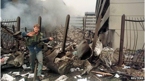 A U.S. embassy official secures the area around the embassy building after a powerful bomb blast in Nairobi (7 August 1998)