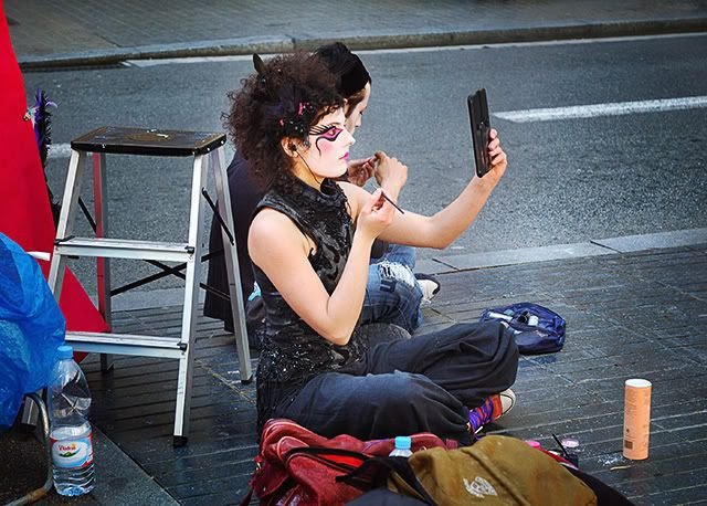 Human statue putting some make-up on her face [enlarge]