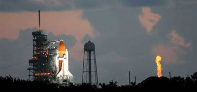A flame shoots out from the launch pad's hydrogen tank as the gas is being burnt off during the filling of Discovery's orange external fuel tank, on the morning of July 4th.