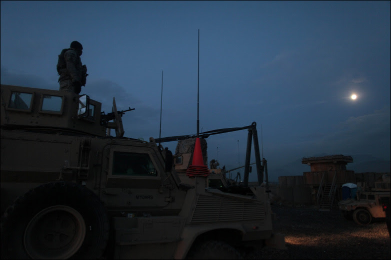 A soldier belonging to a route clearance team stands atop a vehicle as day breaks at Forward Operating Base Airborne